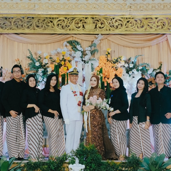 The Ore team posing with the bride and groom on the wedding stage